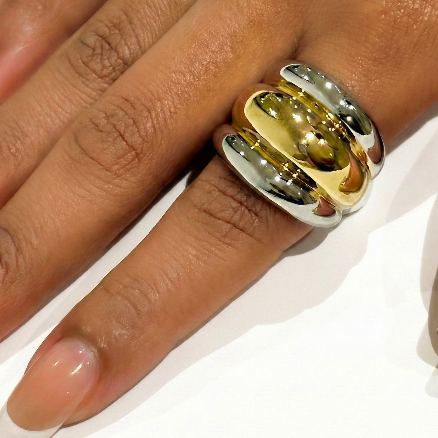 Two-tone Gold and silver ring on a person's finger.