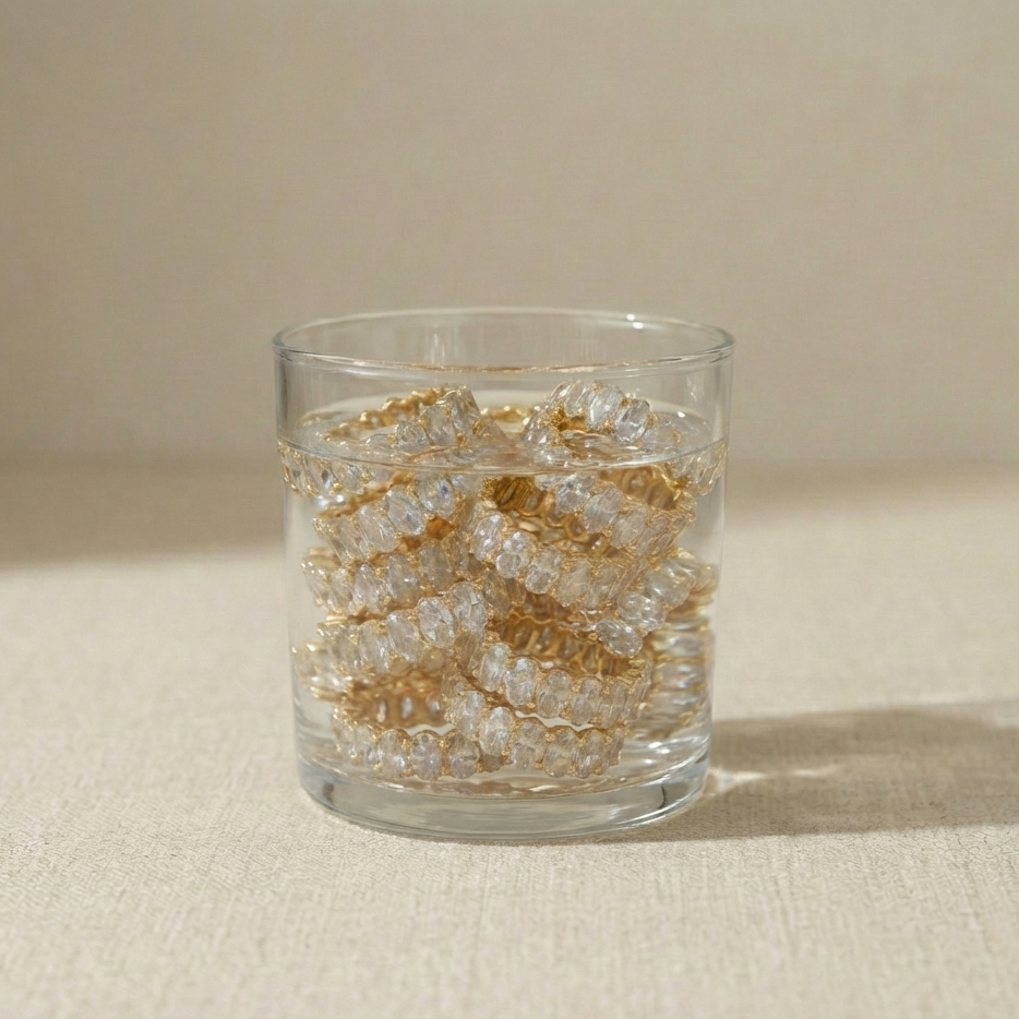 Water glass  with gold tennis rings. 