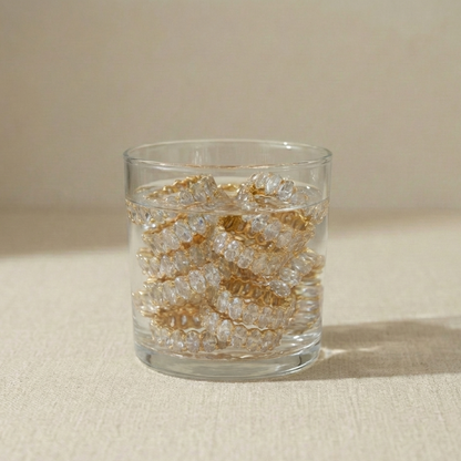 Water glass  with gold tennis rings. 