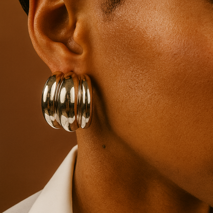 Close-up of an ear wearing a large silver hoop earring.