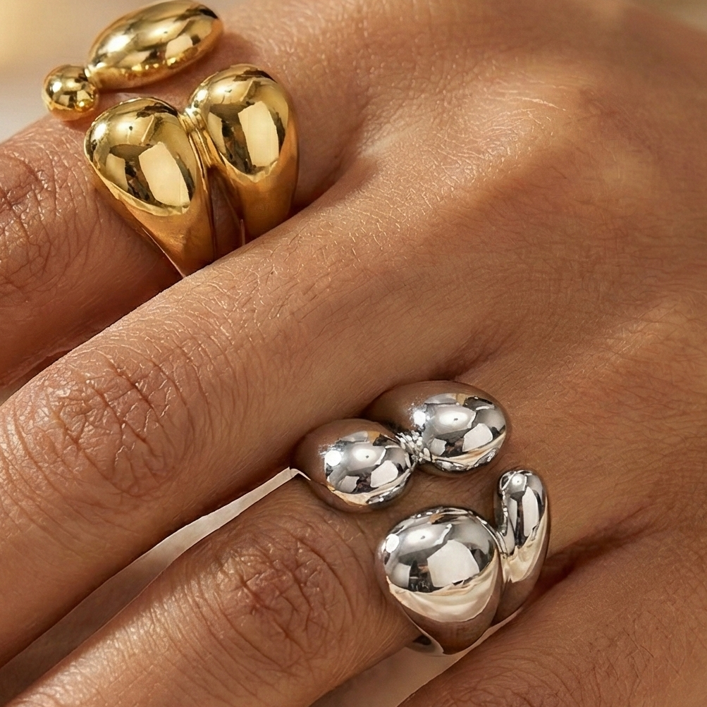 Hand wearing two gold rings.