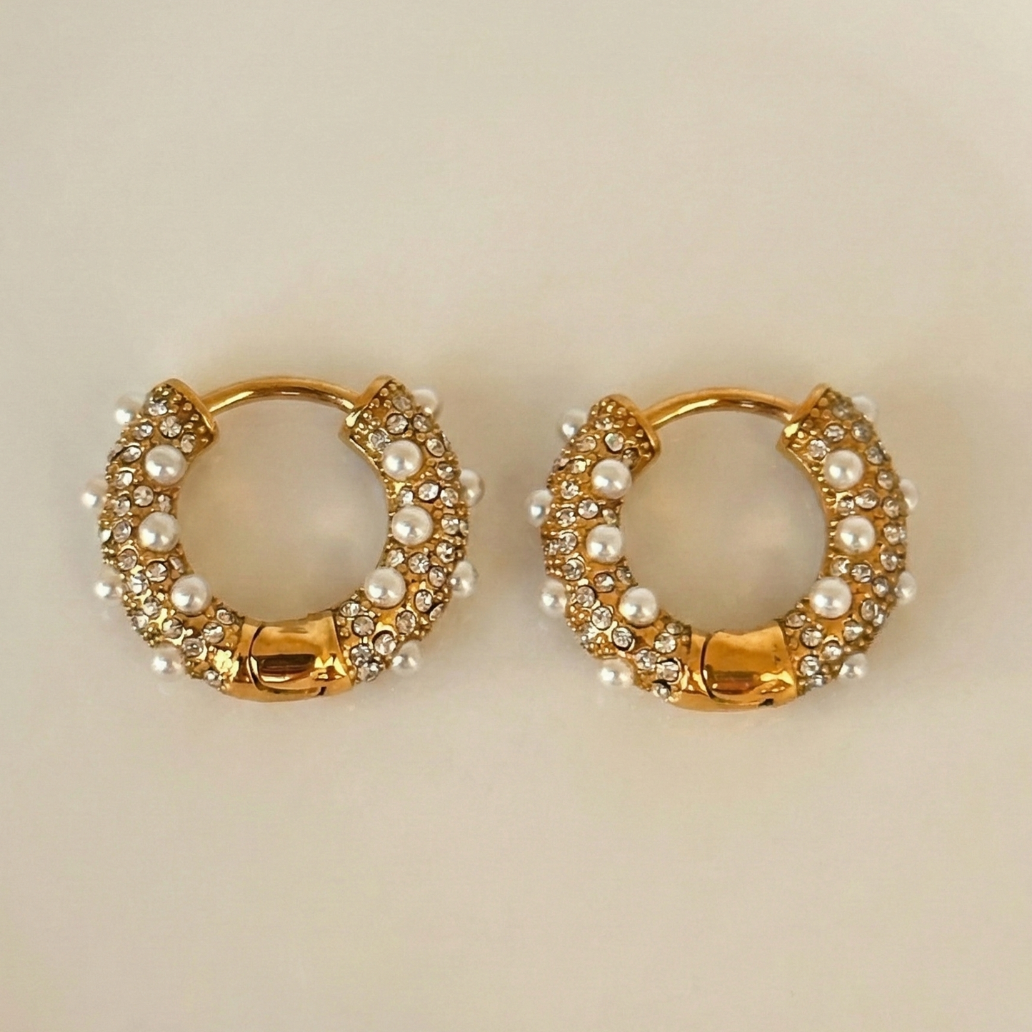 Pair of gold hoop earrings with pearl and gemstone accents. 